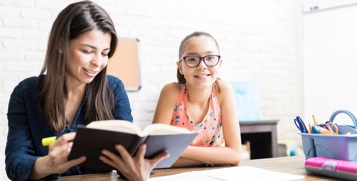 Tutor reading a book to student at home