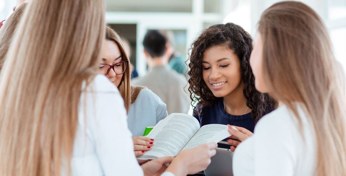 students gathered round looking at a book